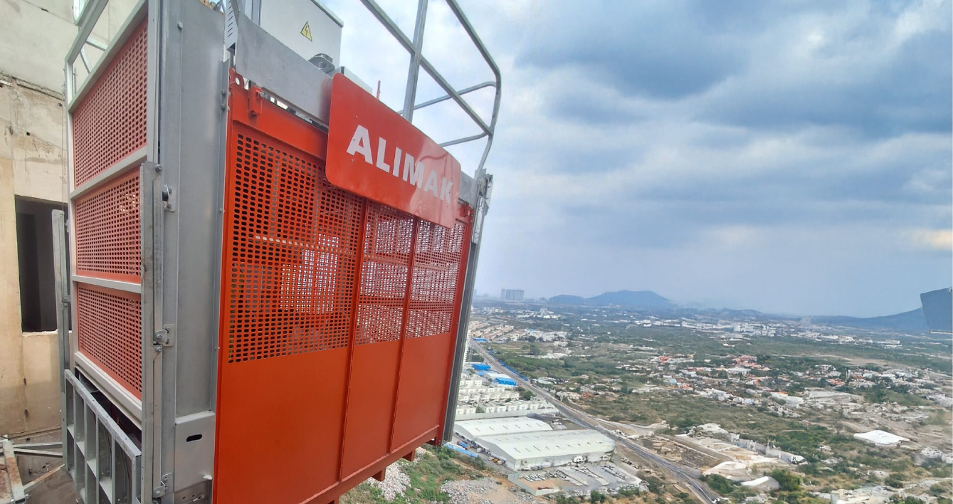 Elevador de construcción Alimak Levato 450 operando en altura en un proyecto de edificación.